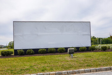 Obraz premium Large white blank roadside sign on a grass lawn with a light