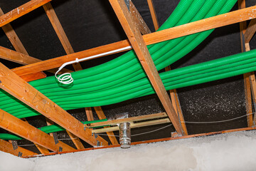 Home energy recovery ventilation, visible system of green flexible pipes for air transport, spread over the roof trusses.