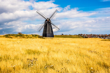 Fototapeta na wymiar A view across Beacon Hill towards a windmill and the town of Rottingdean, Sussex, UK in summer