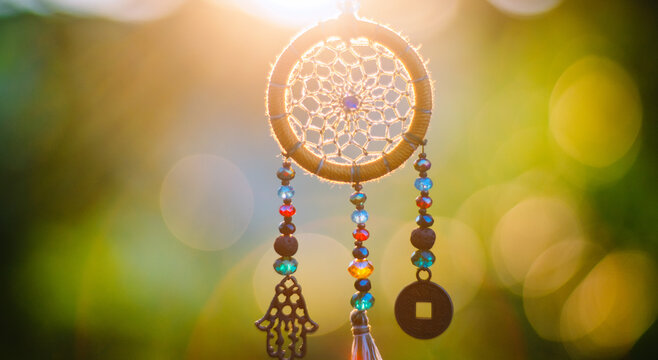 Close up of spiritual necklace with sacred geometry circle with bokeh background backlit by sunset golden light
