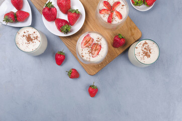 Fototapeta na wymiar Strawberry dessert in a glass jar with strawberries on a gray table