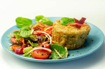 Smoked haddock fishcake with melting cheddar sauce and mixed salad on the blue plate