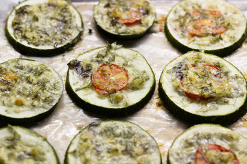 Baked rings of squash with herbs and cheese on pan