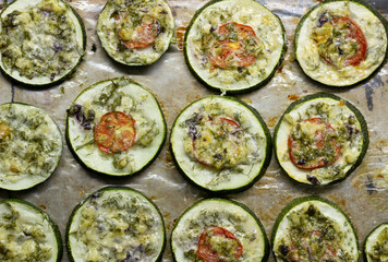 Baked rings of squash with herbs and cheese on pan