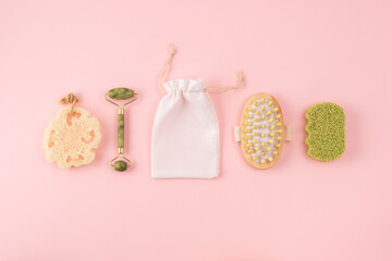 Anti cellulite massager, bamboo sponge, face jade roller, cotton bag, loofah sponge on pastel pink....