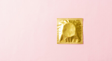 World sexual health or Aids day, Top view flat lay condom in wrapper pack, studio shot isolated on a pink background, Safe sex and reproductive health concept