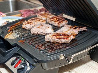 pieces of meat fried on an electric grill, steaks from meat, proper roasting of the grill