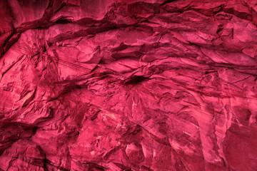 Textured abstract background in raspberry color. Natural rock surface colored for creative design