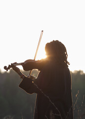 Portrait of black woman musician with violin in nature