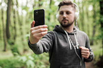Adult sporty man in forest, park running in the morning