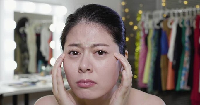 slow motion of surprised young woman singer looking camera as mirror unhappy with wrinkles and eye bags on her face. Human emotions face expression. girl depressed with puffy eyes in dressing room.
