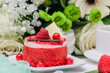 cheesecake with berries and mint.
Homemade raspberry cheesecake close-up on a background of white flowers. Side view.