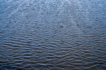 Water surface with ripples and sunlight reflections