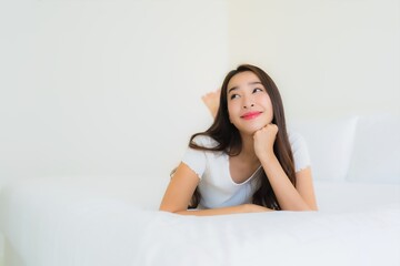 Portrait beautiful young asian woman relax happy smile on bed with white pillow blanket