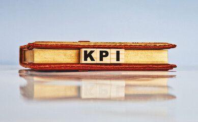 Hand arrange wood letters as KPI acronym Key Performance Indicator.