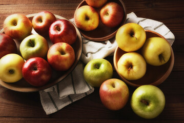 High angle still life of a group of fresh picked varieties of apples, Fuji, Golden Delicious, Braeburn, Granny Smith, and Gala, with warm side light.