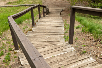 Wooden stairs and handrails leading downward to the beach of a lake.