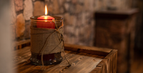Dekoration rote Kerze mit Flame im Glas und Stoff auf echtem Holz
