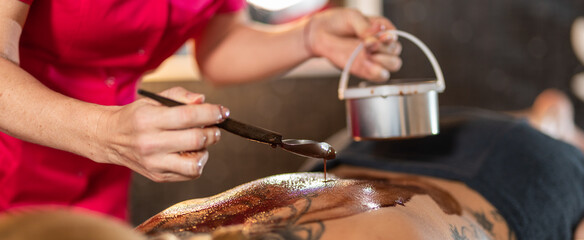 Frau mit heisser Schokolade auf den Rücken. Ganzkörpermassage, Rückenmassage mit heisser...