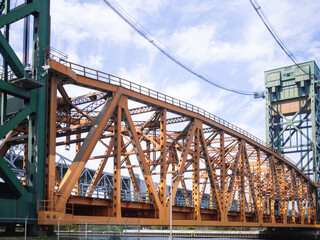 orange steel suspension bridge in summer on a bright summer day