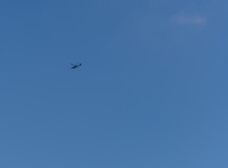Helicopter flying in clear blue sky.