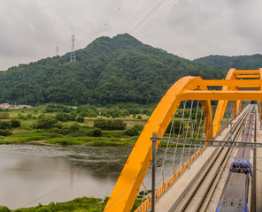 Top view of train crossing yellow bridge