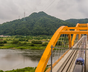 Top view of train crossing yellow bridge