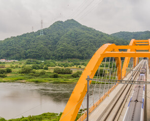 Top view of train crossing yellow bridge