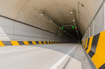 Two lane highway tunnel of white concrete