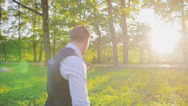 young man violinist in the nature sun beam playing the violin classic