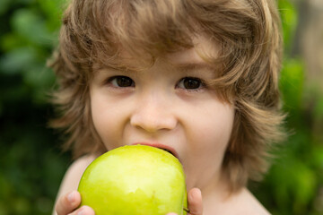 Kids eating apple. Little boy biting apple in sunny garden. Healthy nutrition for kids. Solid food for infant.