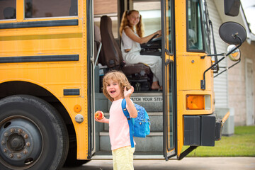 Child getting on school bus. Back to school and happy time. Little ready to study. Home education. © Volodymyr