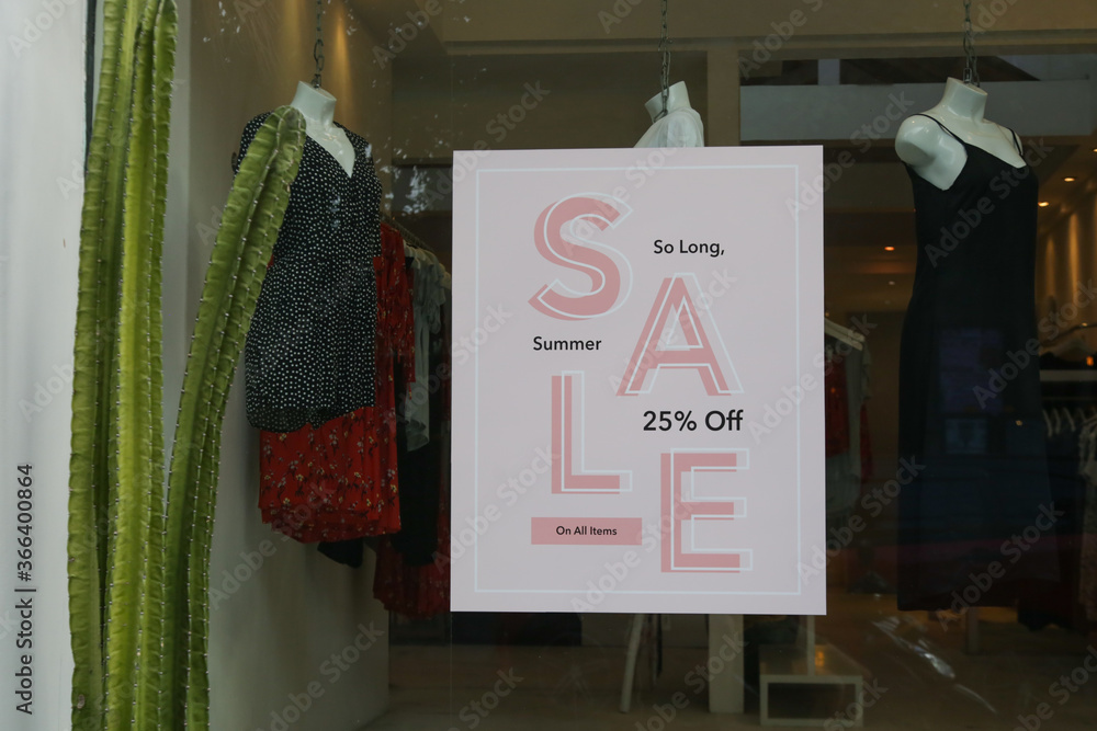 Wall mural Sale sign on the window of clothing store - seasonal shopping concept	