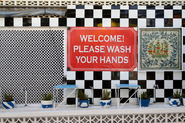 Outdoor hand basins and wash your hands sign at the entrance of restaurant. Safety measures during coronavirus outbreak.