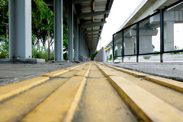 Yellow tactile paving guide path leading to a bus stand, installed to assist the visually impaired...