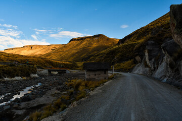 Carretera de tierra con una vivienda de tapial en medio de los Andes del Perú - Huancavelica