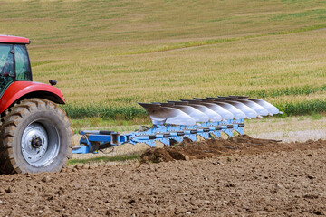 Plowing the field. Large plow on a tractor. Tractor with agricultural attachment.