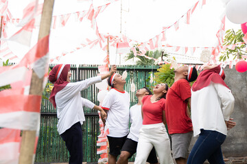 asian young men and young women joined in cracker eating contest in the celebration of August 17 Indonesian Independence Day