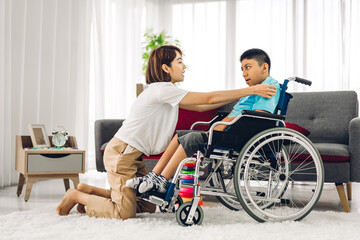 Fototapeta na wymiar Portrait of asian physiotherapist carer helping and playing with special disabled child health problem by doing exercises sitting in wheelchair in rehabilitation clinic.disability care concept