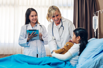 Obraz premium Smiling woman doctor service help support discussing and consulting talk to little girl patient give teddy bear and check up information in hospital