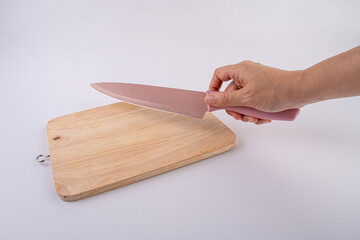 Close-up - hands with a knife on a wooden board,white background