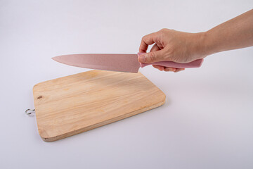 Close-up - hands with a knife on a wooden board,white background