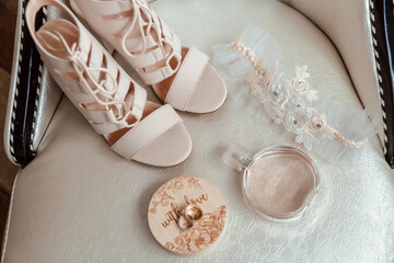 beige shoes for the bride, wedding rings, perfume, garter.