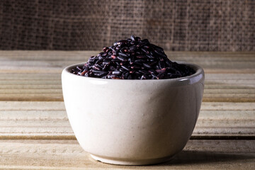 black venus rice on glass bowl isolated on wooden table in Brazil