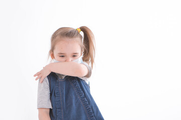Portrait of a child on a white background who wears a medical mask. Demonstration of medical equipment. The girl sneezes