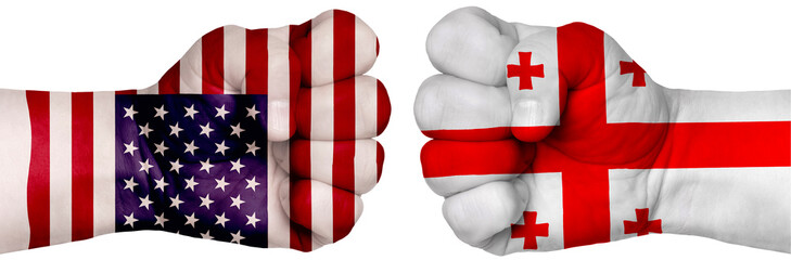 Fototapeta premium Two hands are clenched into fists and are located opposite each other. Hands painted in the colors of the flags of the countries. Georgia vs USA