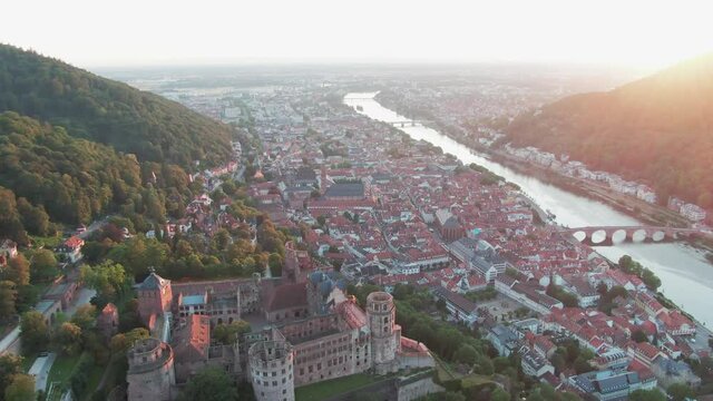 Beautiful aerial drone slide towards the cityscape of Heidelberg while sunset with the heidelberg palace in the foreground
