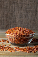 red rice on glass bowl isolated on wooden table in Brazil