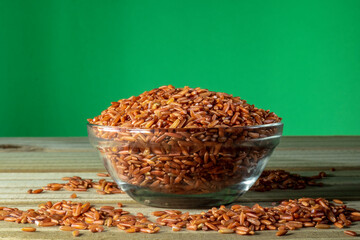 red rice on glass bowl isolated on wooden table in Brazil