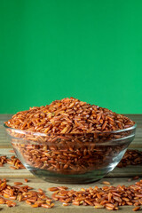 red rice on glass bowl isolated on wooden table in Brazil
